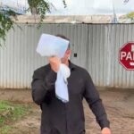 Motorista que matou vigilante na JK cobre rosto ao sair da delegacia